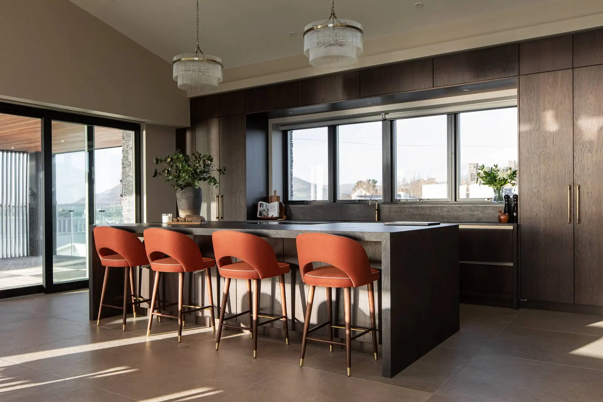 Dorans open plan modern kitchen island with chocolate oak cabinetry and brass bar handles